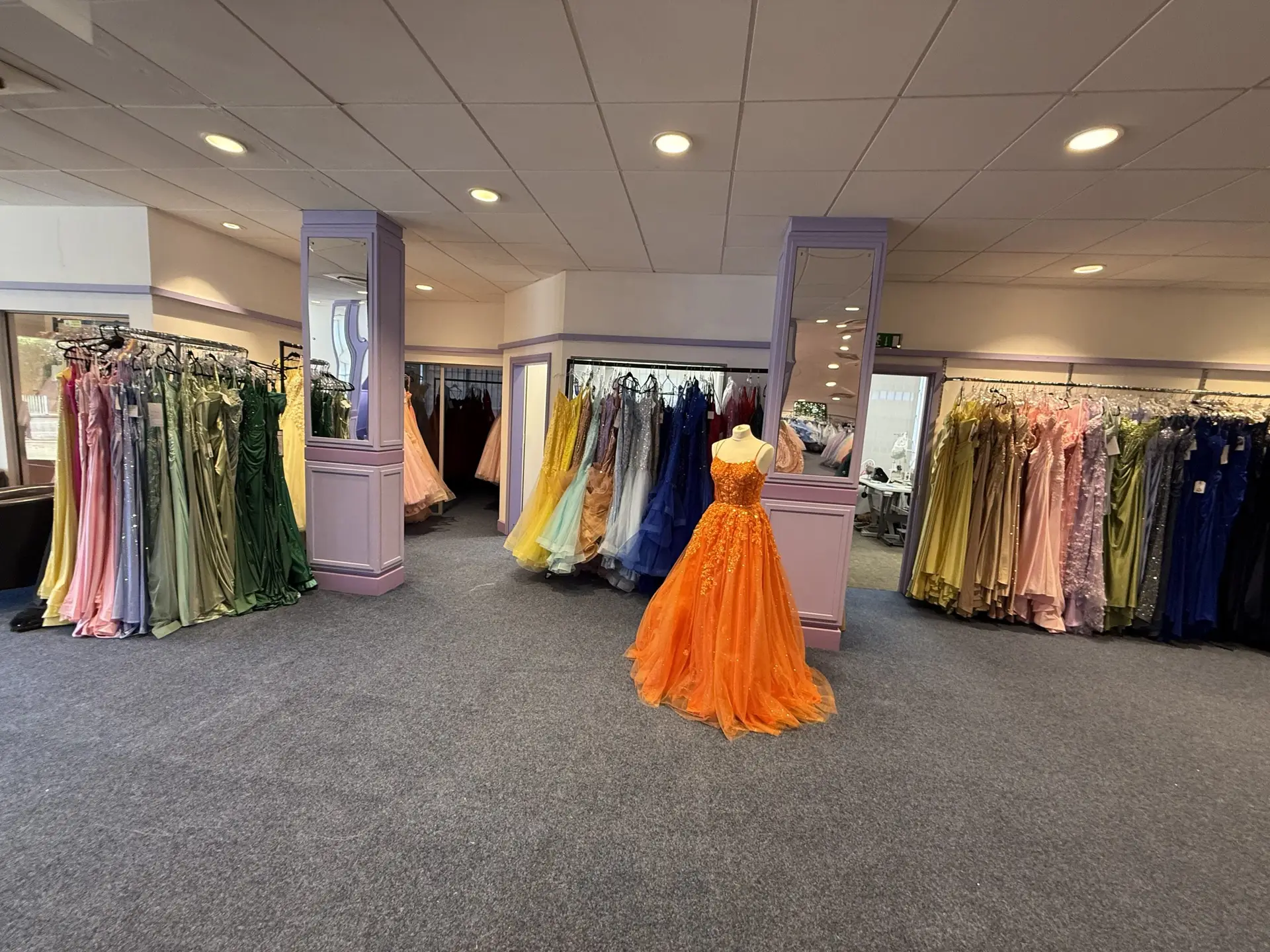 Real MK Outlet showroom in Bletchley with colourful prom dresses and an orange ballgown